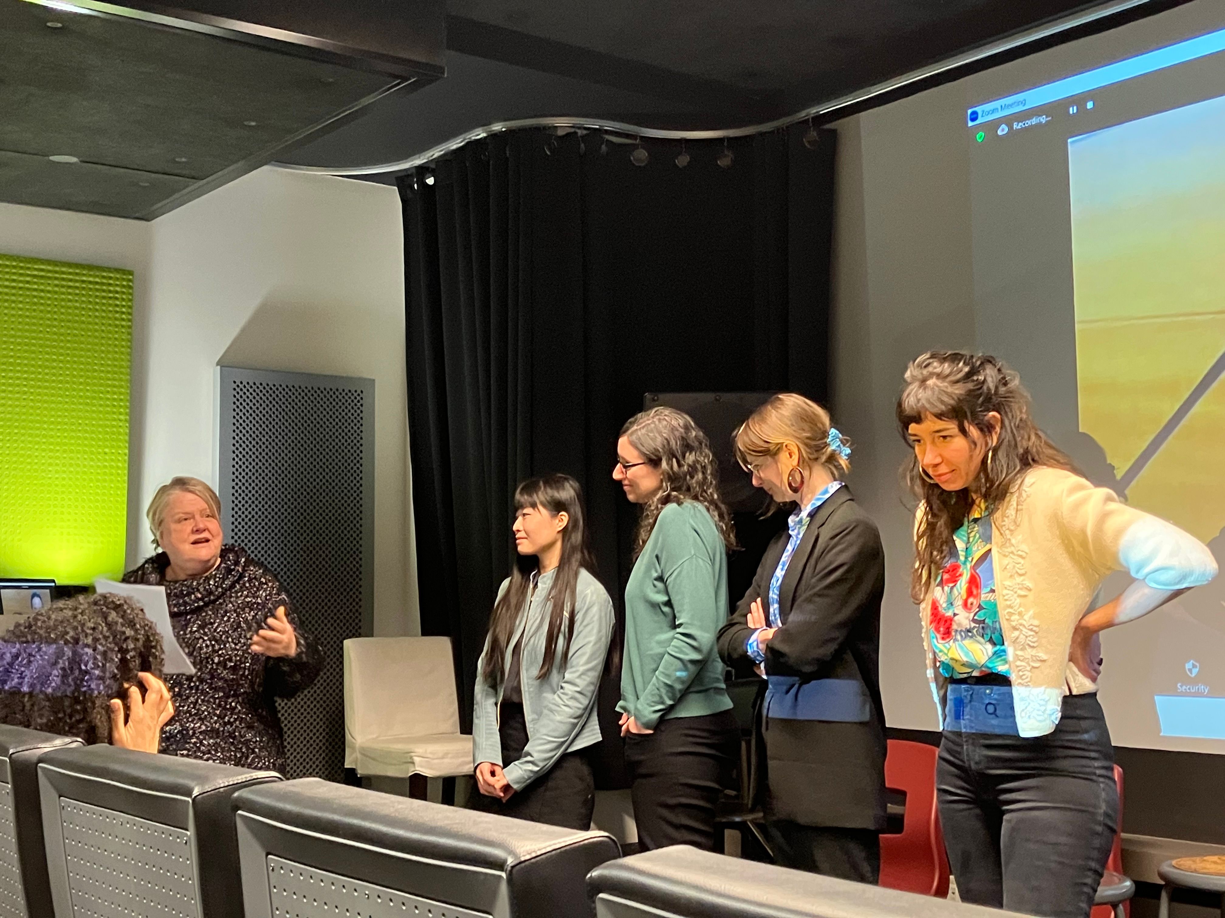 Cinq femmes devant une salle répondent à des questions. 